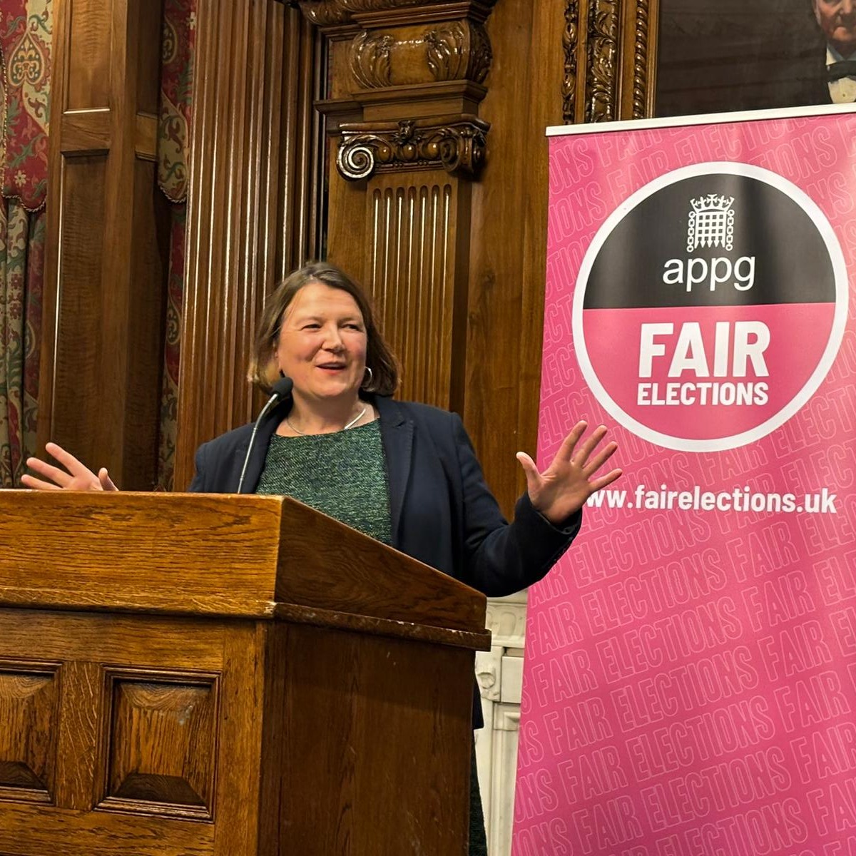 Ellie Chowns MP in a wooden panelled room in the middle of a speech on electoral reform.