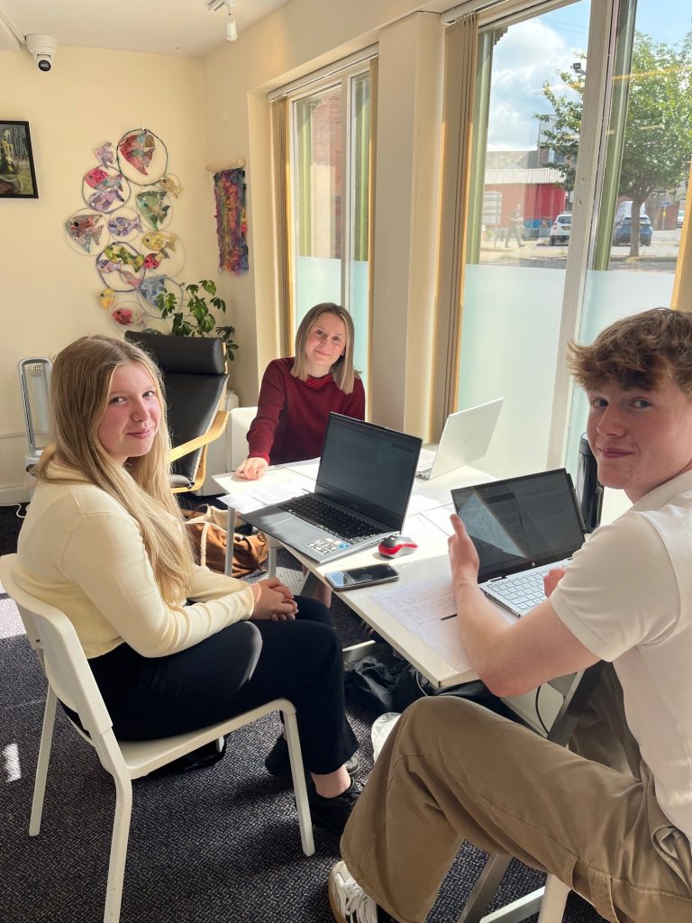 Group of three teenagers in an office.