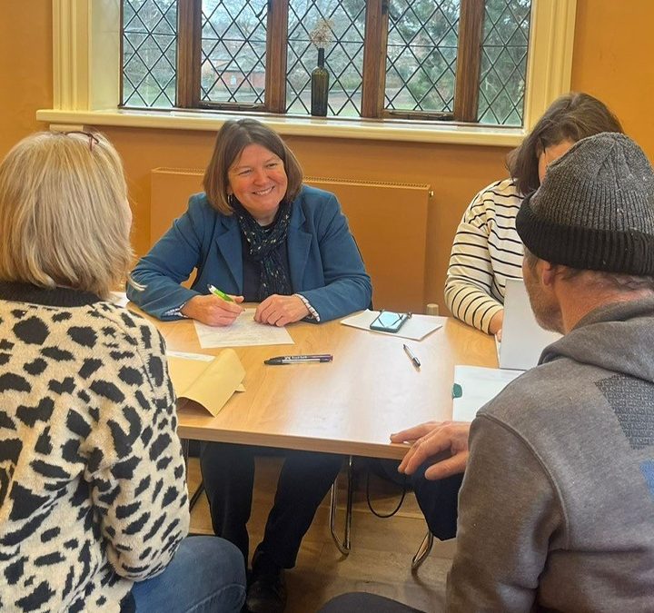 Ellie Chowns sitting with her caseworker are sitting and talking to two other people